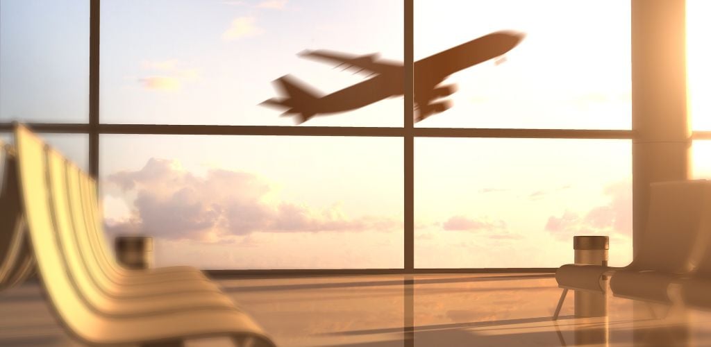 airport boarding lounge with aeroplane taking off in the background