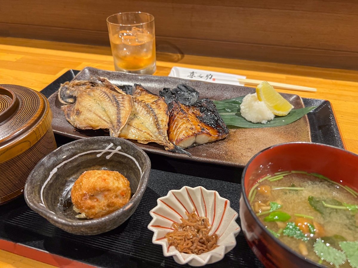 A platter of grilled fish, miso soup, fish cake, and umeshu.