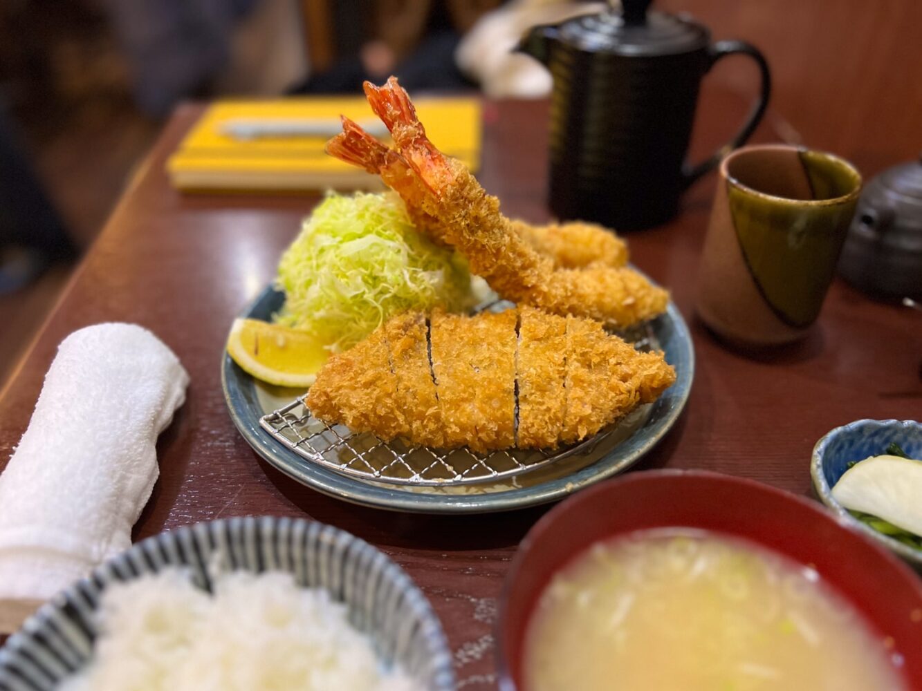 Plate of Japanese Tonkatsu (pork cutlet) and shrimp tempura with side dishes of rice and miso soup.
