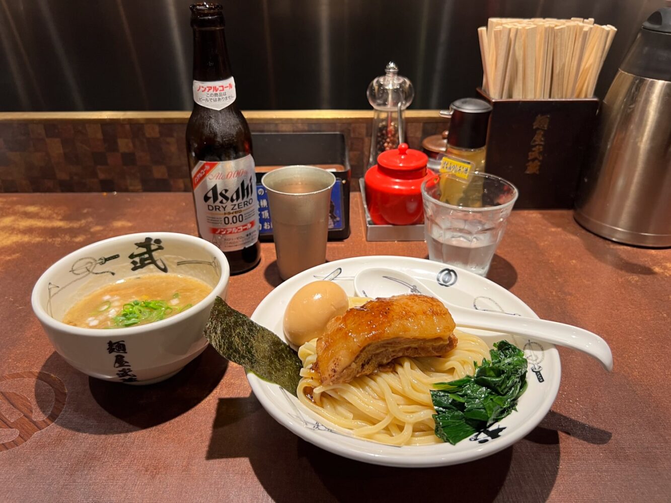 Japanese meal featuring Tsukemen Ramen noodles with side dish of dipping sauce and an Asahi beer.