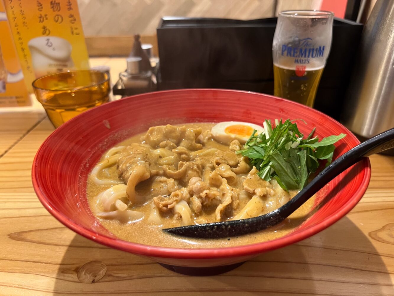 Big red bowl of Japanese curry udon with pork.