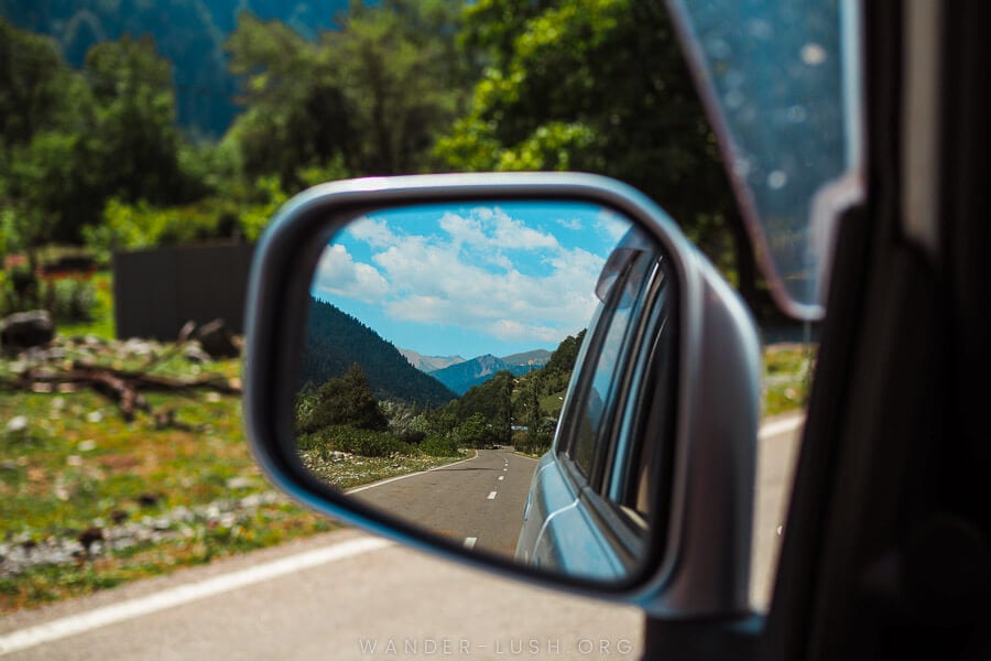 A side mirror shows a mountain road in Georgia.