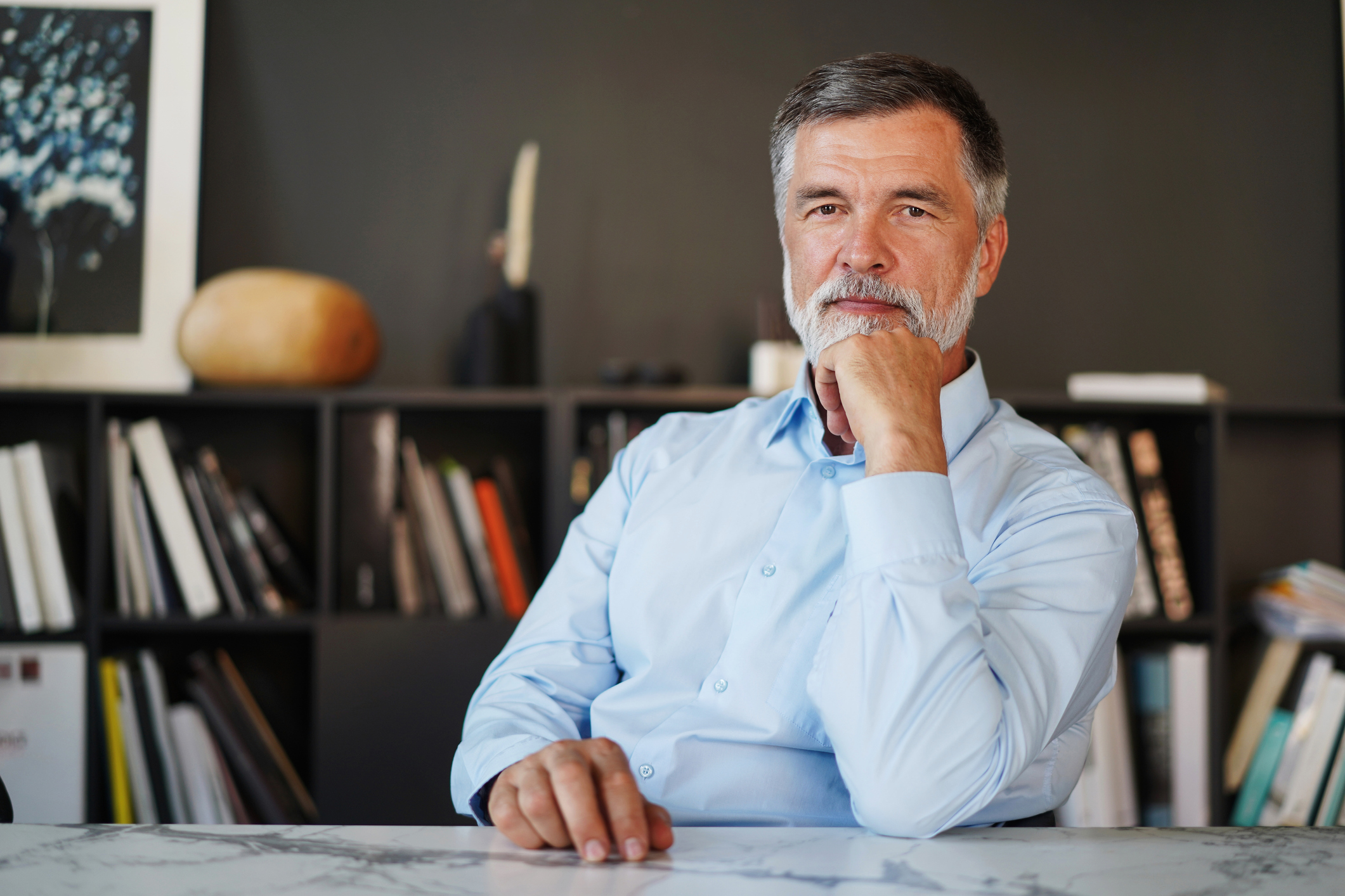 A person seated at a desk looking pensive.