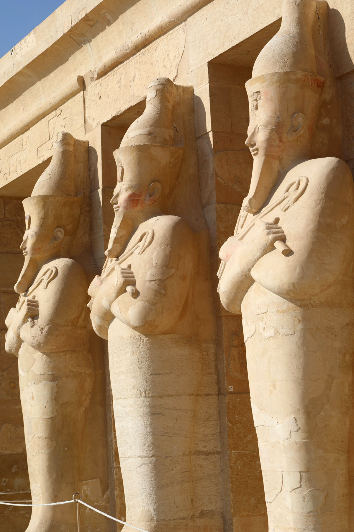 A row of identical enormous statues of Hatshepsut at her temple in Luxor.