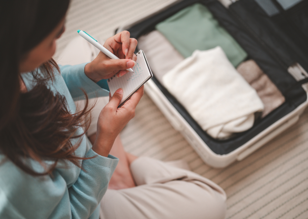 Woman with notebook and packing checklist.