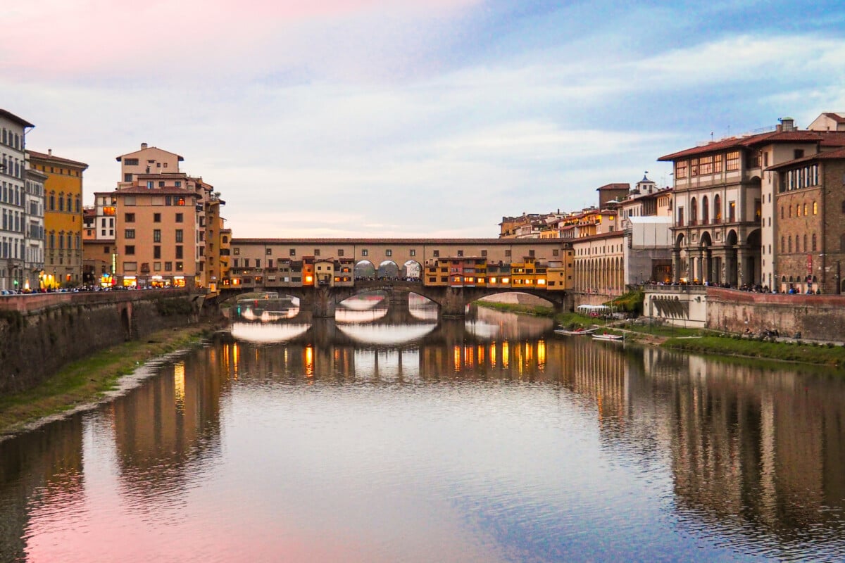 For the image with the filename slug "ponte-vecchio-florence" and the image title "Ponte Vecchio, Florence," the alt text should be "View of Ponte Vecchio bridge over the Arno River in Florence, Italy, surrounded by historic buildings and shops."