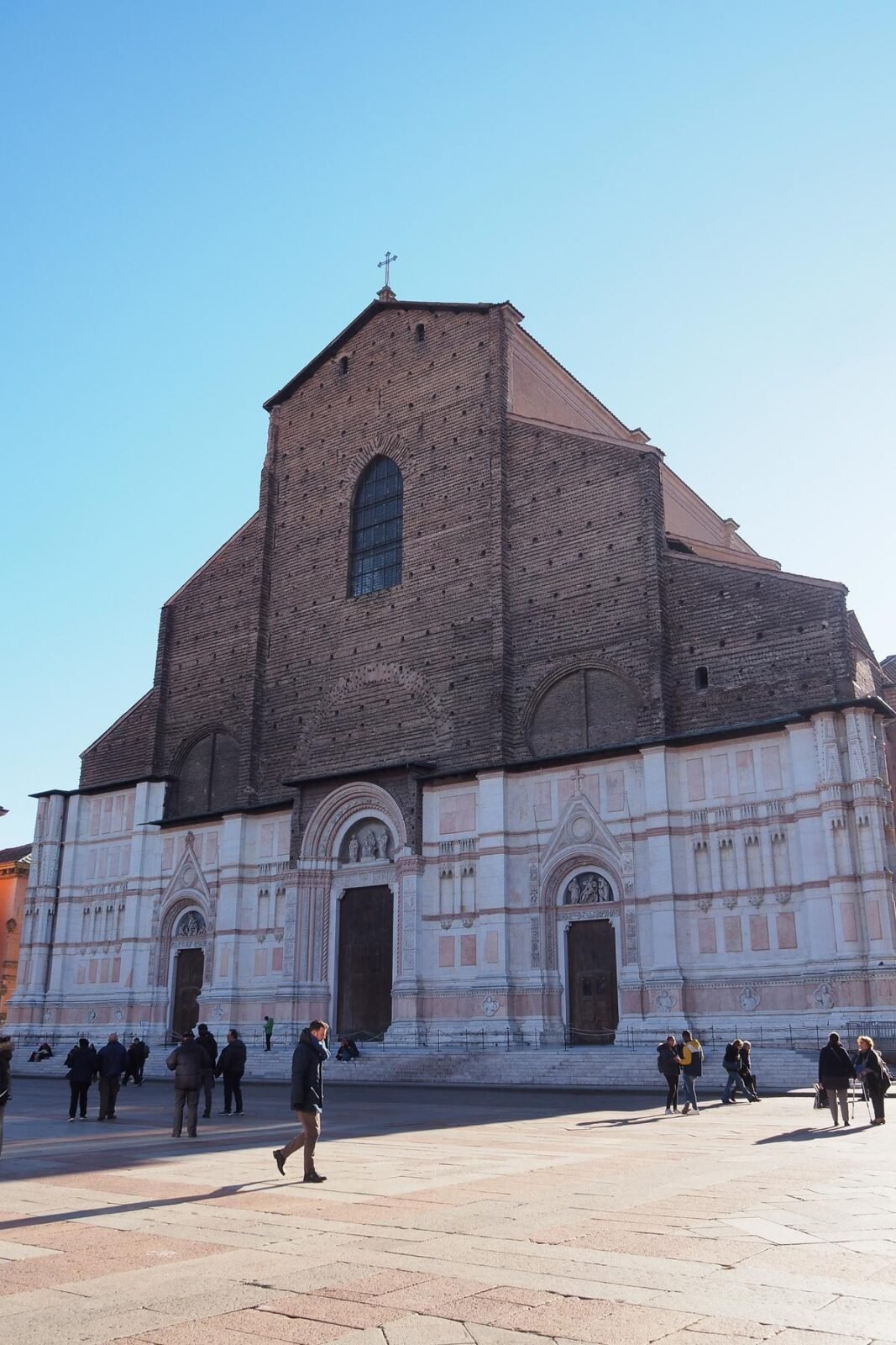 Sunny Basilica San Petronio and Piazza Maggiore in Bologna with visitors