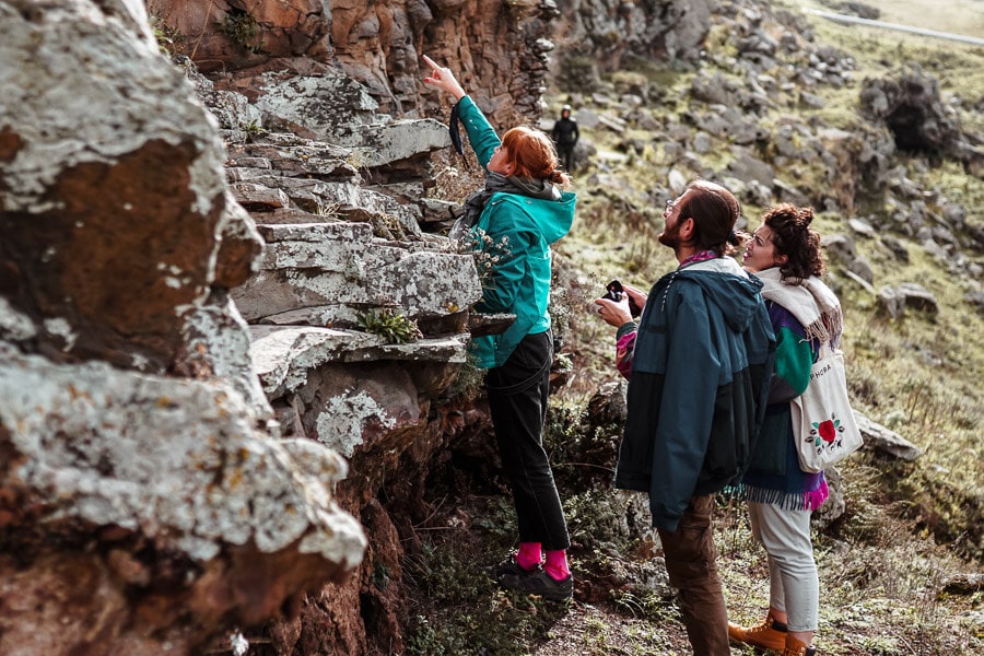 Three people searching amongst the rocks for petroglyphs near the Georgian town of Tsalka.