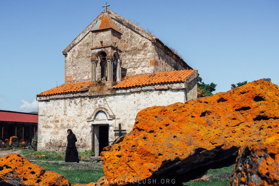 An ancient stone church and megalithic ruins covered in orange lichen in the village of Saro, Mestkheti.