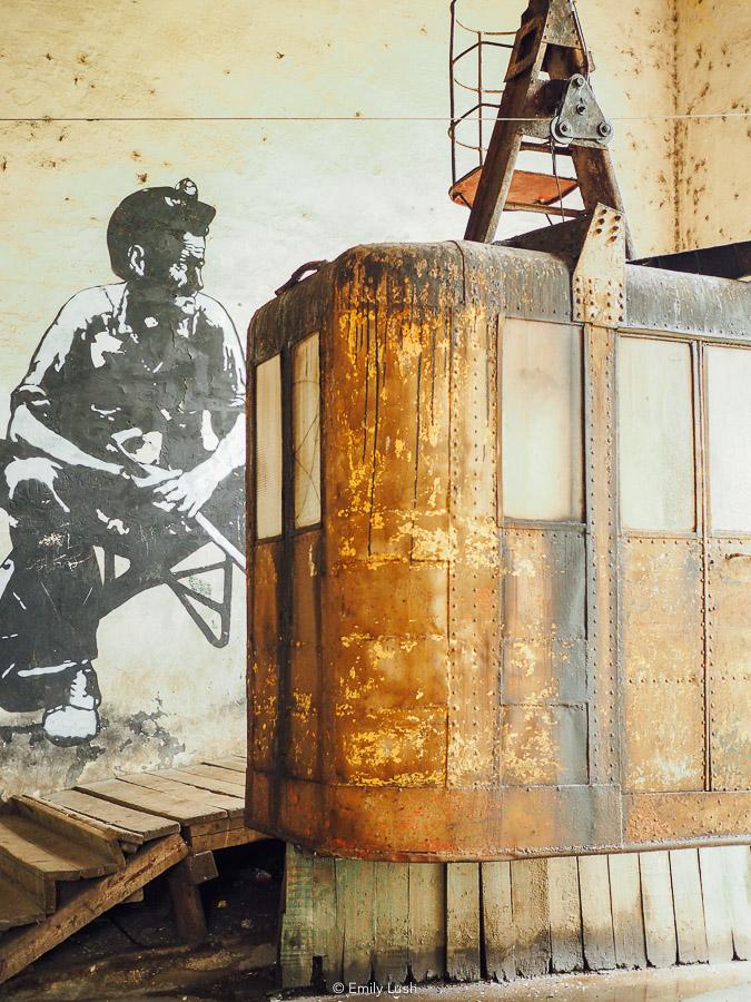 An old cable car in front of a street art mural in Chiatura.