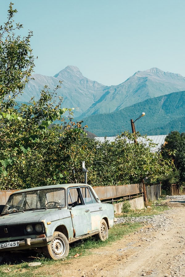 A green car parked on a mountain road in Racha, Georgia.