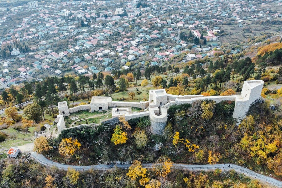 Modinakhe Castle in Sachkhere, Georgia, a medieval castle surrounded by fall foliage.