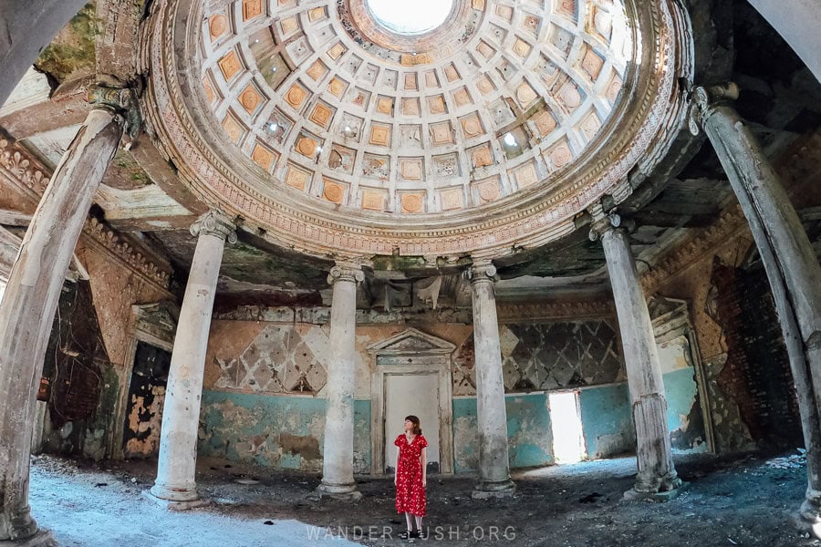 Emily in a red dress standing beneath the dome of the Menji sanatorium in Samegrelo.