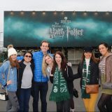 Talia witha group of friends in front of a Harry Potter billboard.