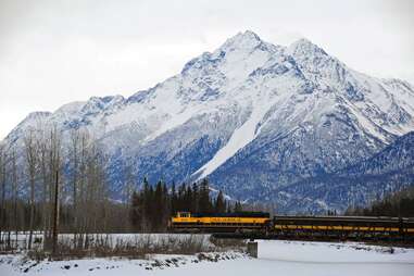 an Alaska Railroad train with a massive mountain behind 