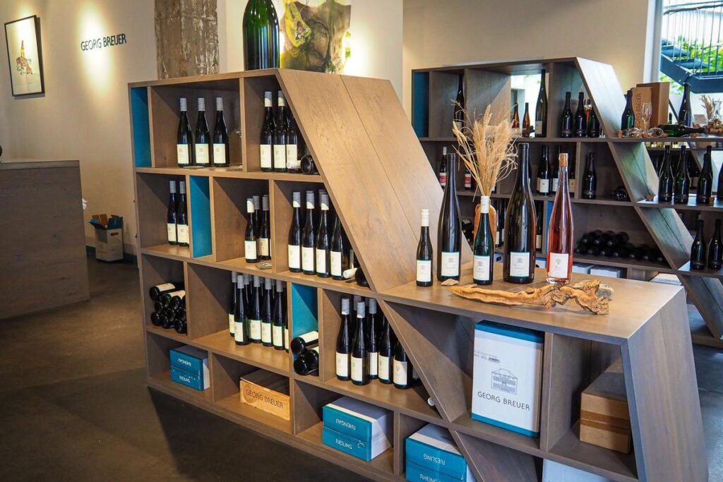 Weingut Georg Breuer wine shop interior showcasing premium Riesling bottles, wooden shelves, and elegant branding.