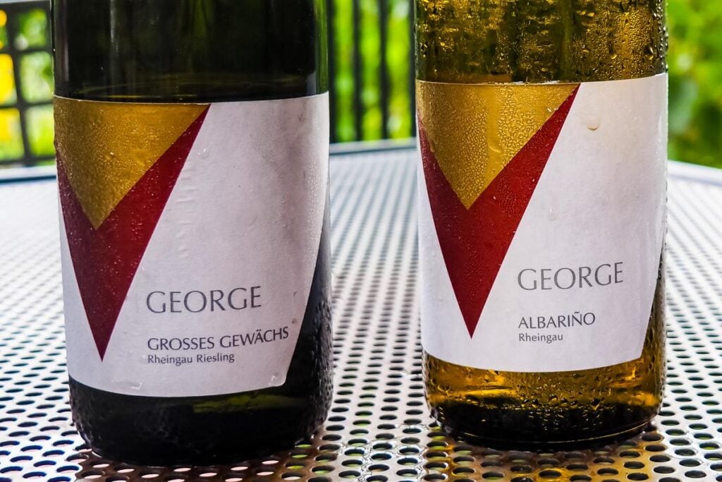 Chilled wine bottles featuring 'GEORGE' vineyard labels - Rheingau Riesling Grosses Gewächs and Albariño Riesling with condensation beads, perfect for wine connoisseurs.