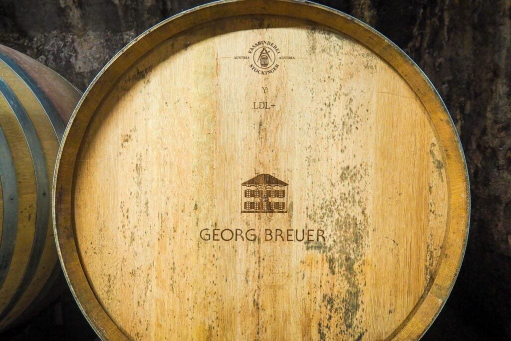 Close-up of Georg Breuer wine barrel in traditional cellar, showcasing Stockinger cooperage craftsmanship and oak aging process for fine wines.