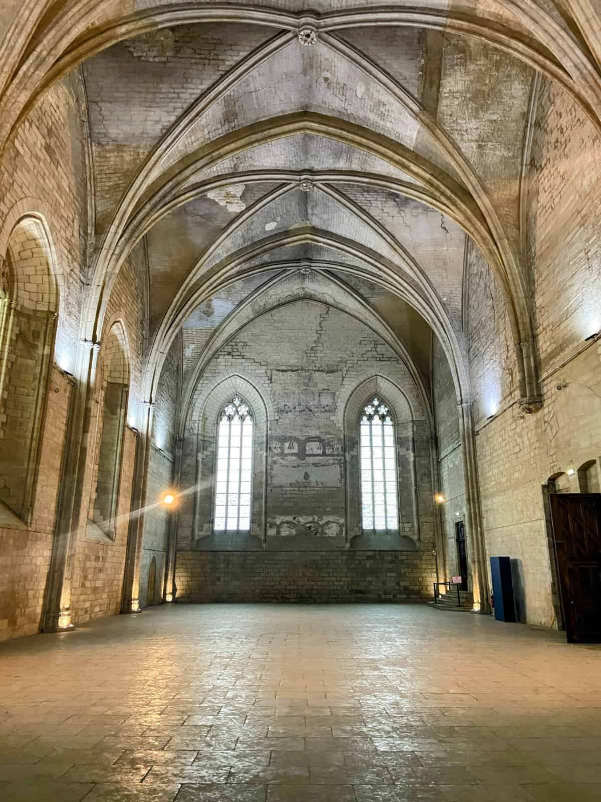 One of the large rooms inside the Palais des Papes with an arched ceiling