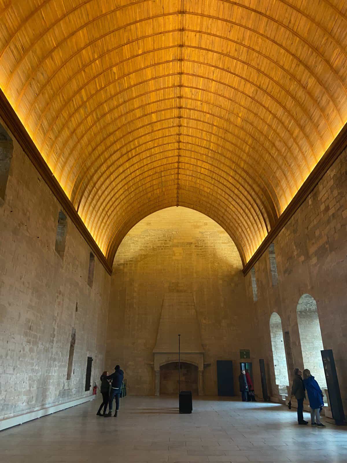 A large room inside the Palais des Papes with an arched golden ceiling, one of the top things to do in Avignon