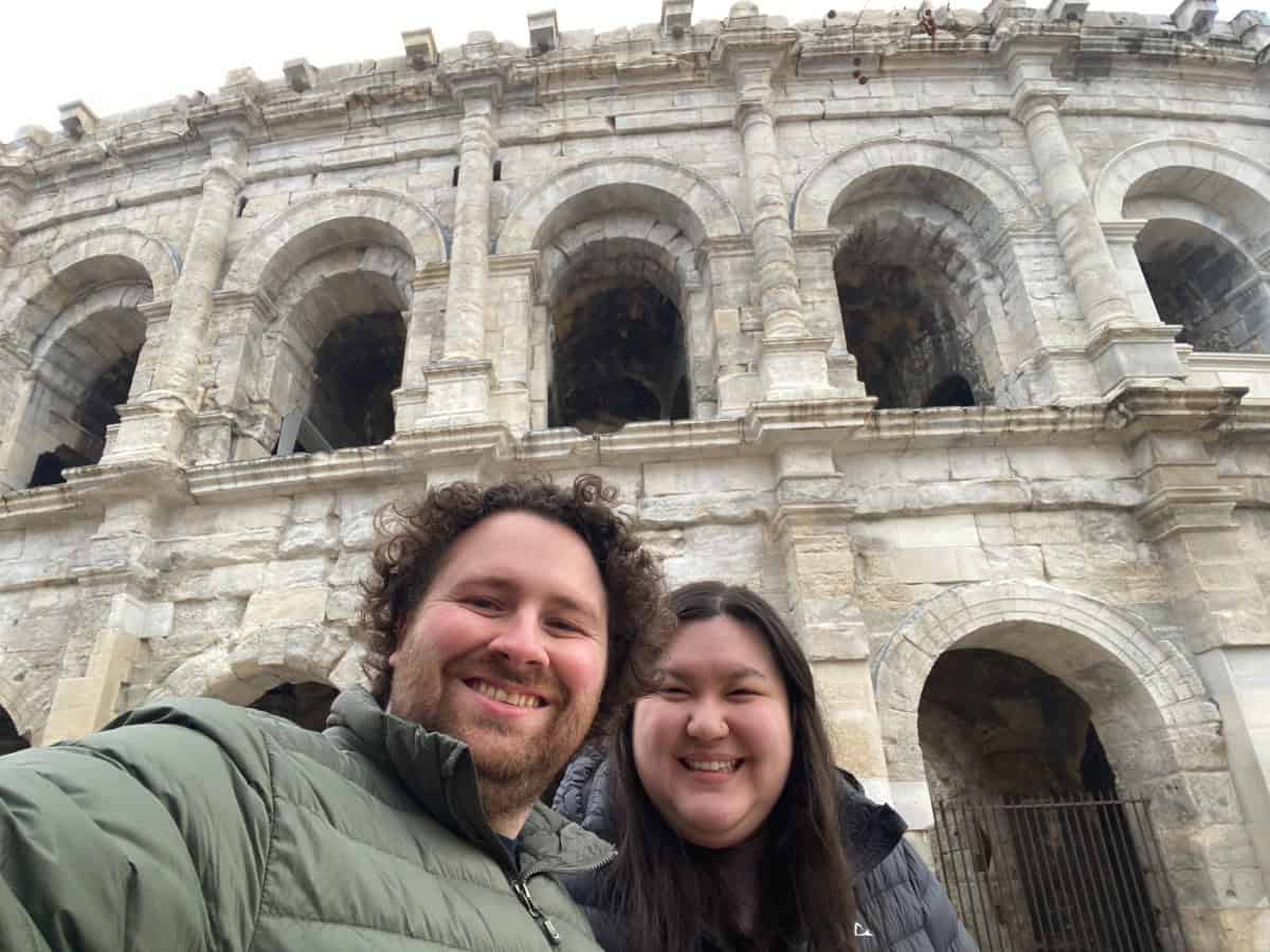 Riana and Colin taking a selfie in front of Les Arenes de Nimes, France