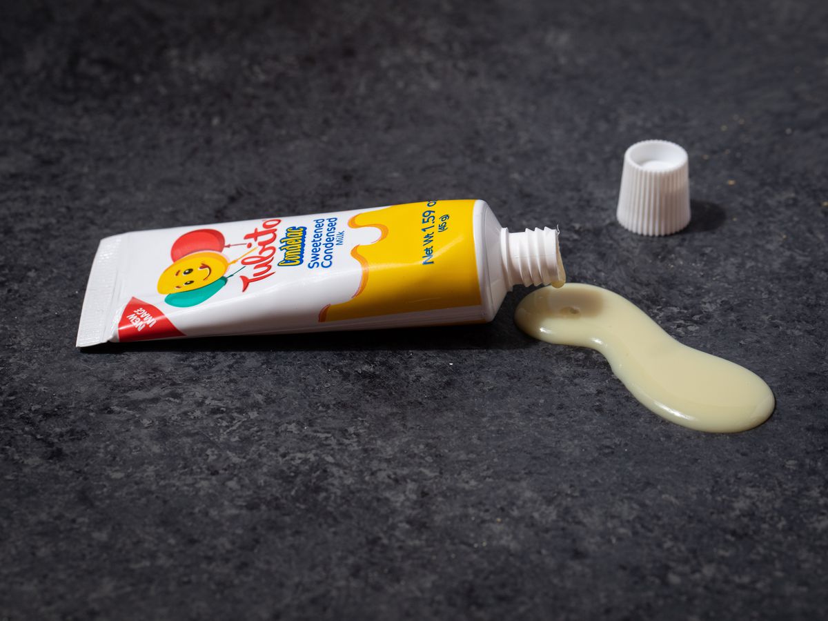 A tube of condensed milk with some of the contents squeezed out