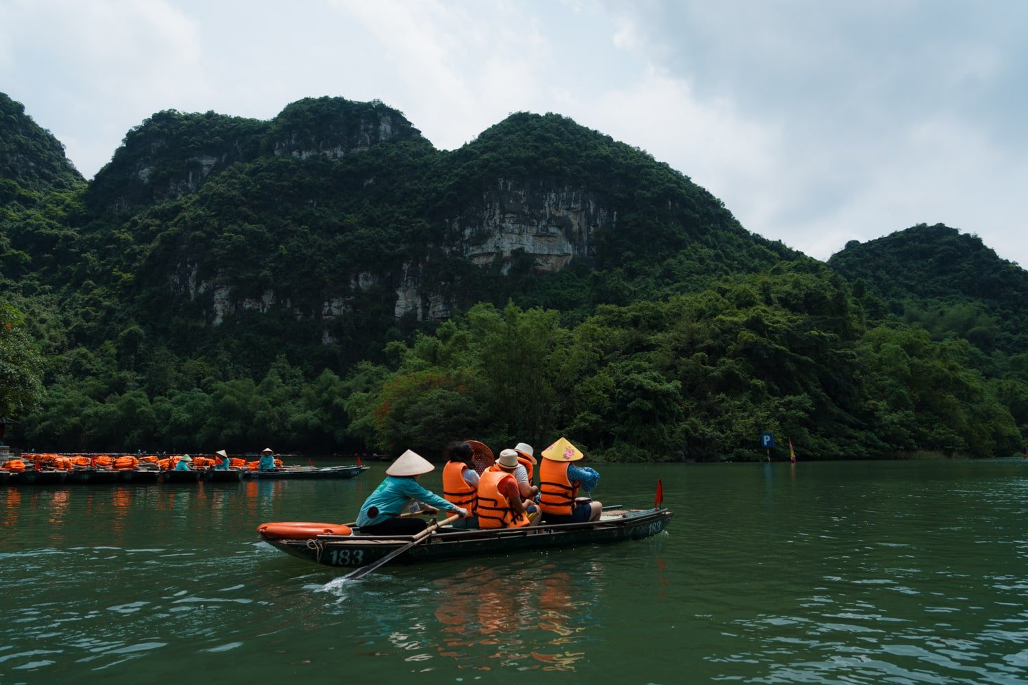 Vietnamese sampan boat with tourists in Trang An Scenic Complex Landscape, Vietnam.