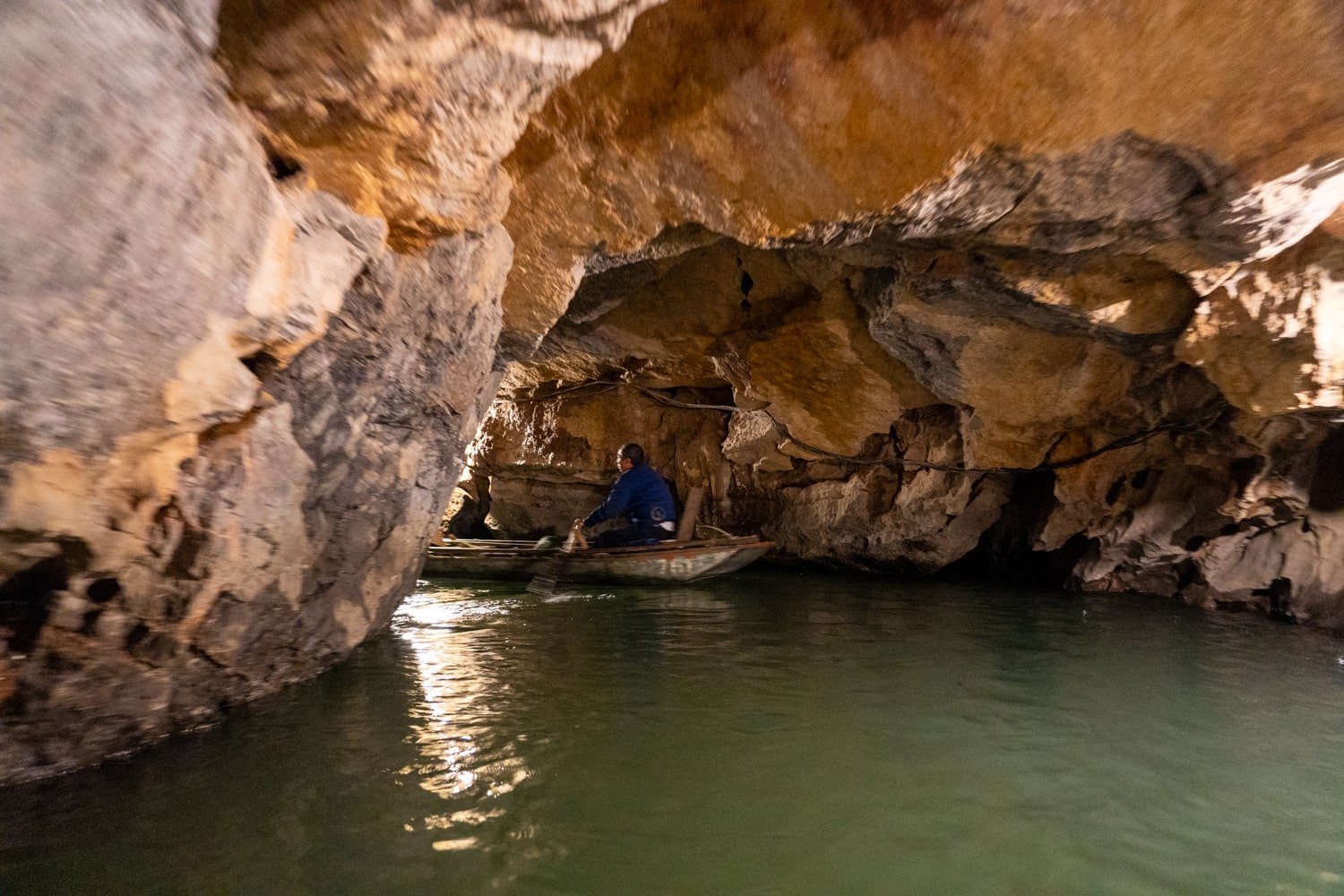 A boat tour enters one of the grottoes of Trang An Scenic Complex Landscape in Vietnam.