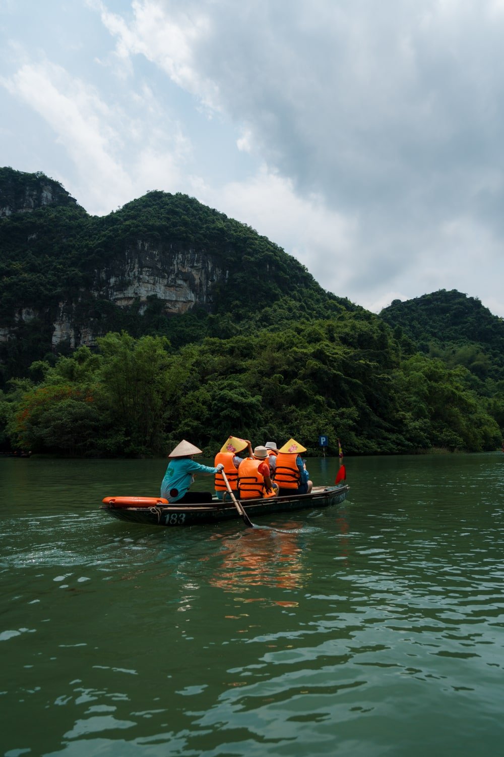 Vietnamese sanpam boat with tourists in Trang An Scenic Complex Landscape, Vietnam.