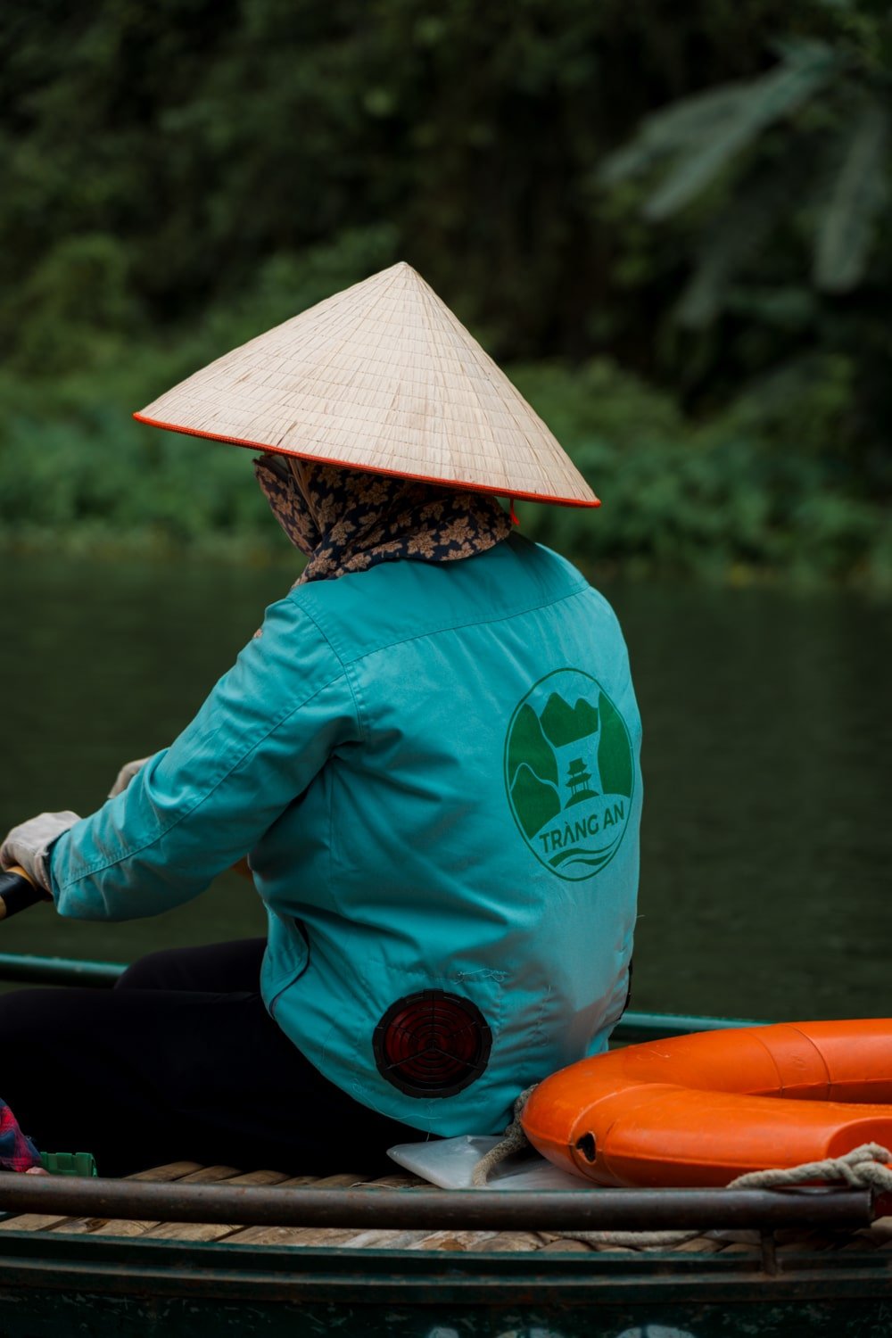 A certified Trang An boat rower wearing traditional Vietnamese hat.