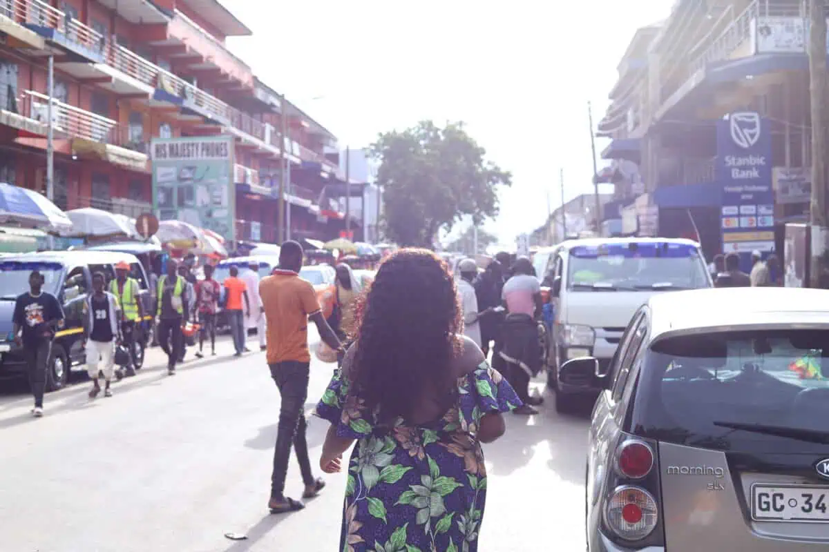 Christina Jane walking with her back to the camera in a Ghana Market