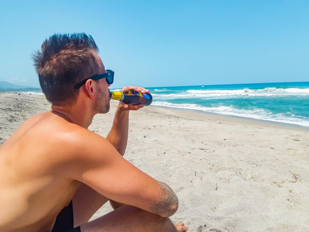 Daniel enjoys a beer on Palomino Beach, Colombia