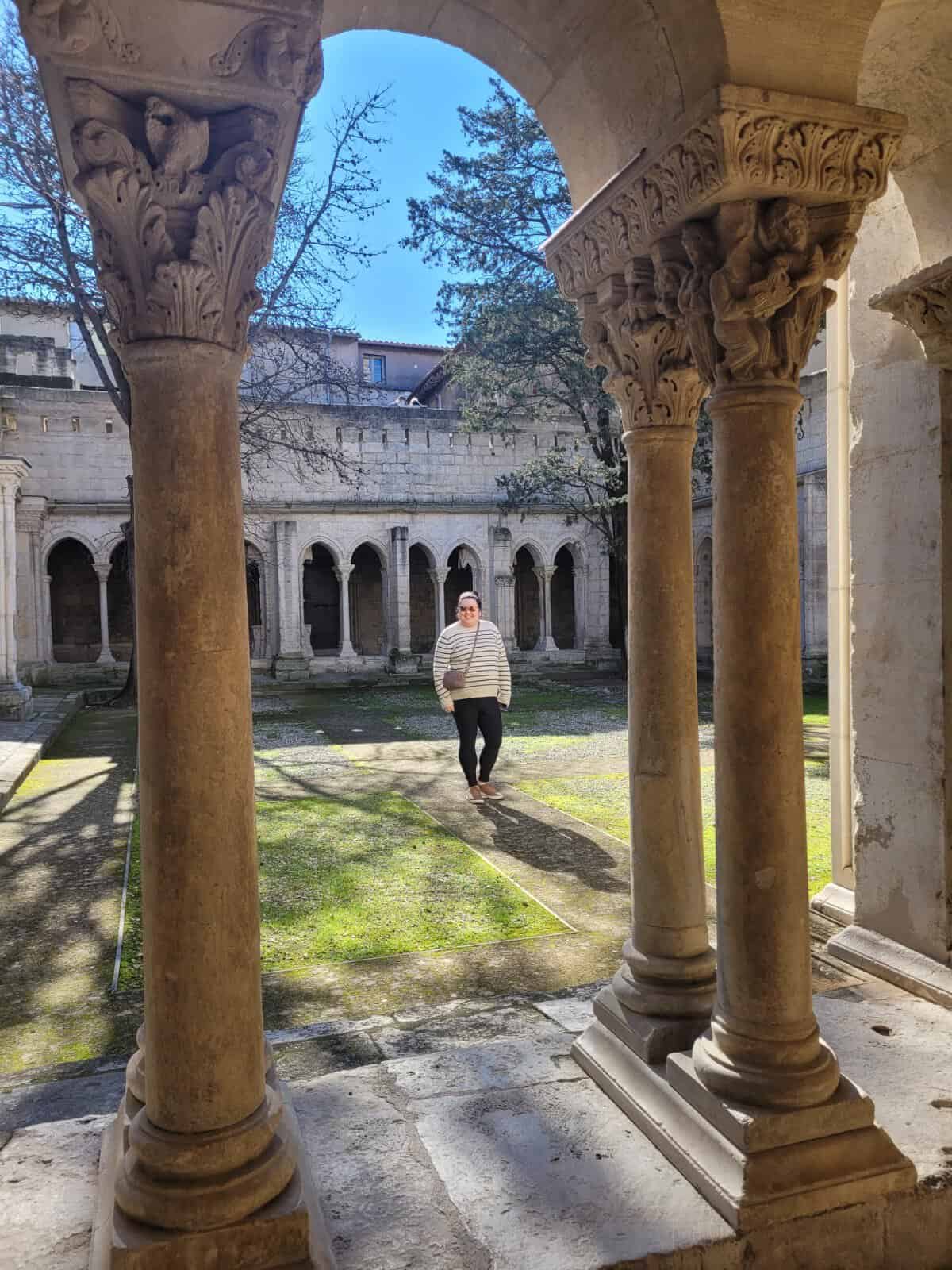 Riana in the courtyard of the Cloître Saint-Trophime or Cloister of St. Trophime in Arles, France