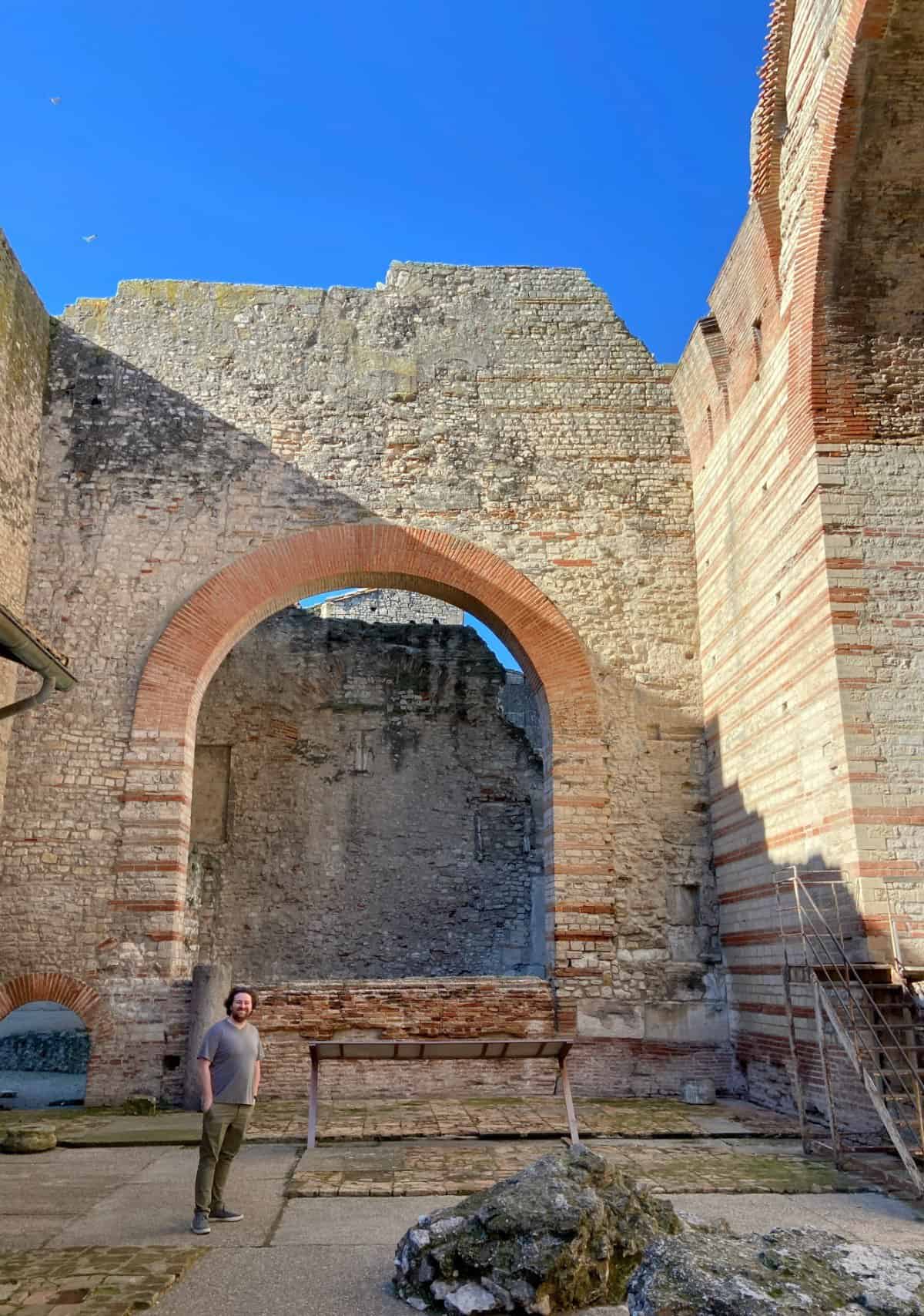 Colin standing in the Thermes de Constantin or Baths of Constantine in Arles, France