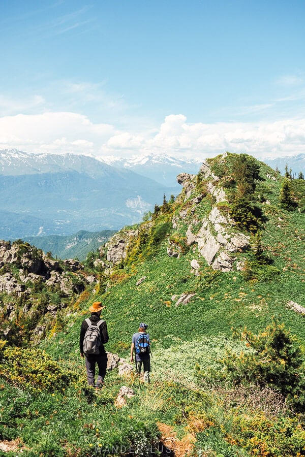 Two men hiking past limestone formations on Mount Khvamli near Kutaisi.