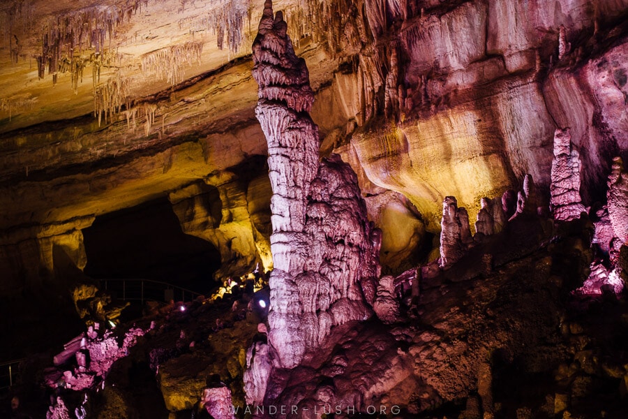 A cave formation at Sataplia Cave lit by purple and yellow lights.