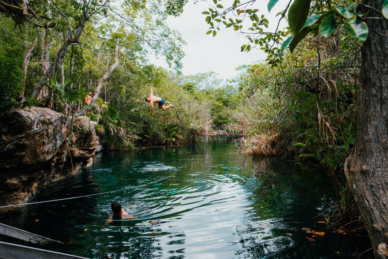 guy jumping into cenote escondido in tulum