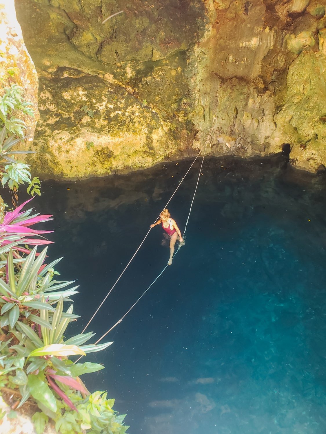 Girl swimming in a blue cenote (3 Oches) in Yucatan, Mexico.