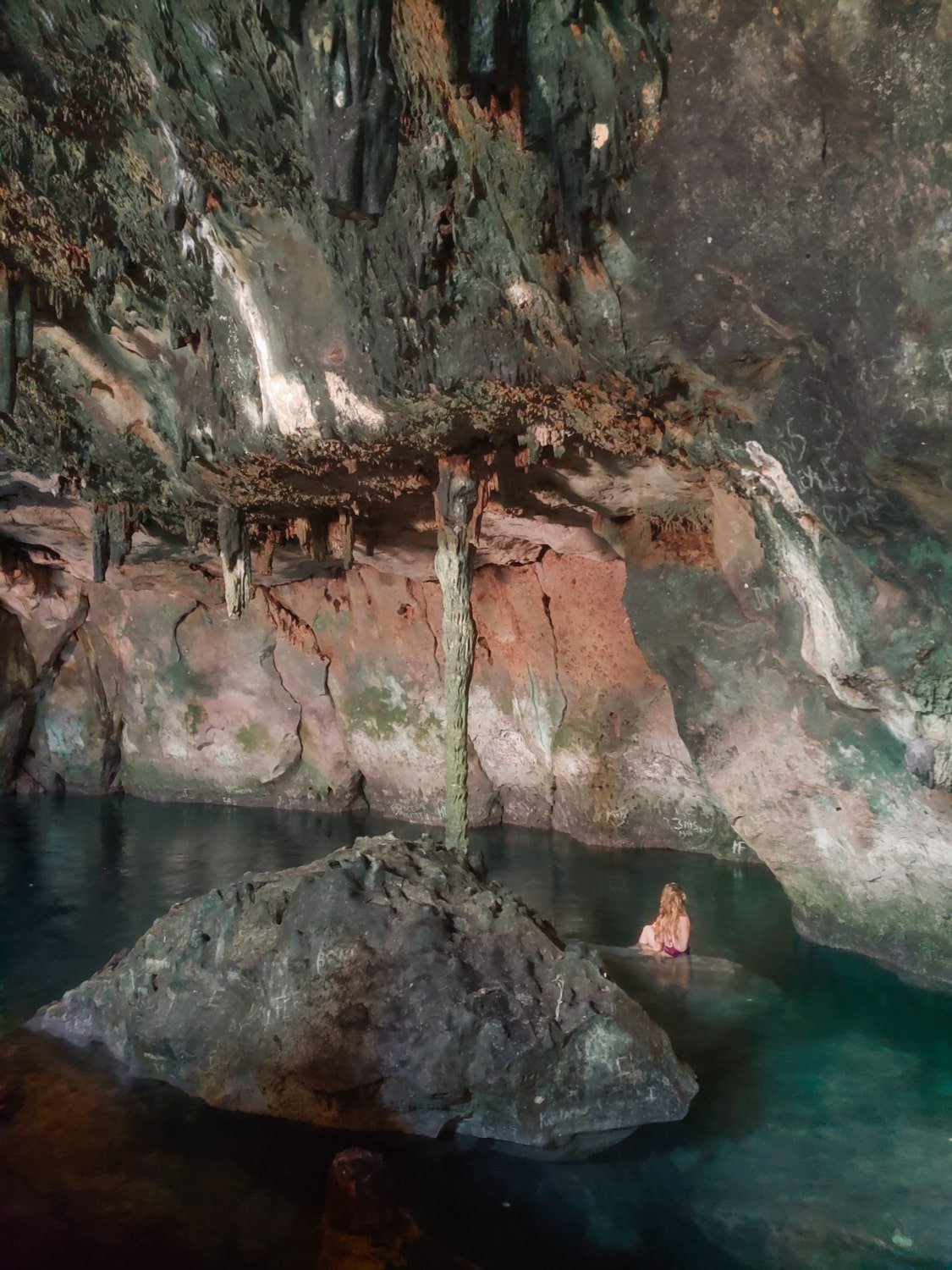 Travel girl in a semi-open cave cenote in Homún, Yucatán, Mexico.