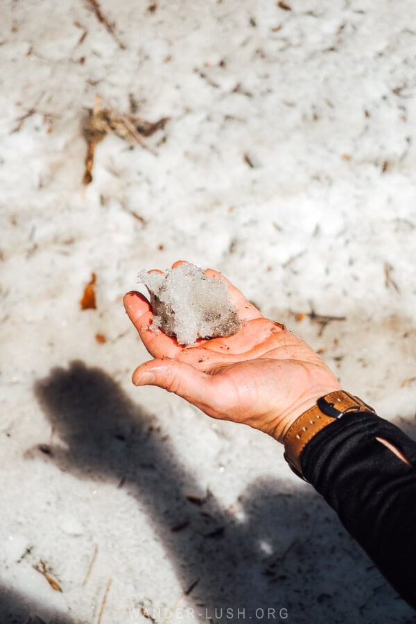 A man holding out a ball of ice.