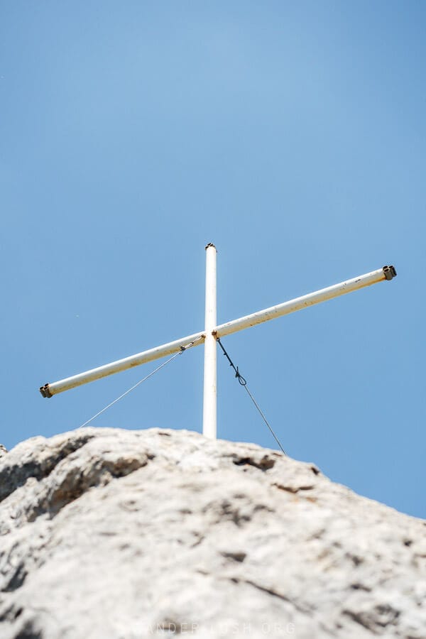 A white cross mounted on a rock at the highest point of Khvamli Mountain in Georgia.