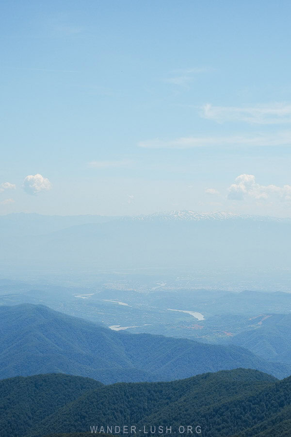 View of the mountains and a river in Georgia from the peak of Khvamli Mountain.