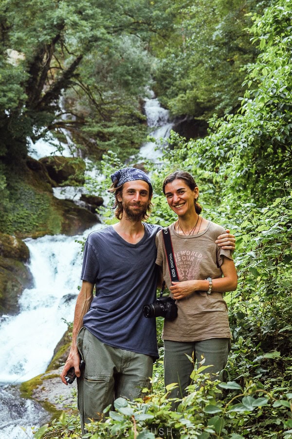 Two people pose for a photo in front of Rachkha Waterfall on the way from Kutaisi to Khvamli Mountain.