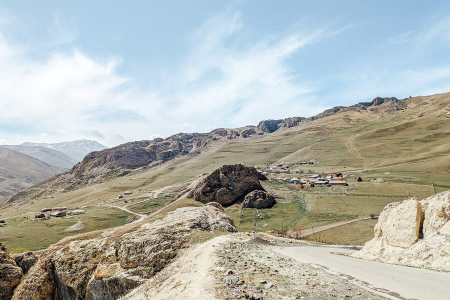 View of rocky mountains with a paved road cutting through the hills in Khinaliq, Azerbaijan.