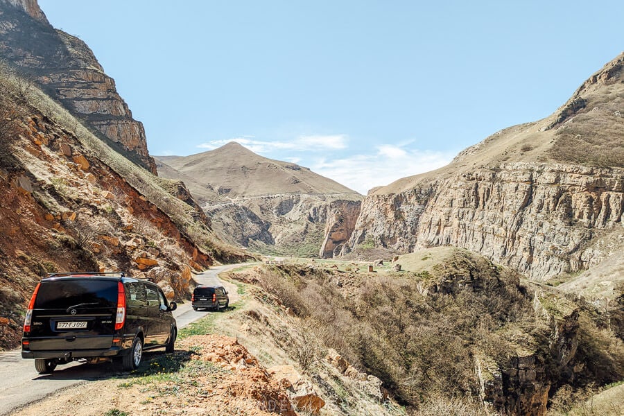 Two black vans on a winding road to Khinaliq.