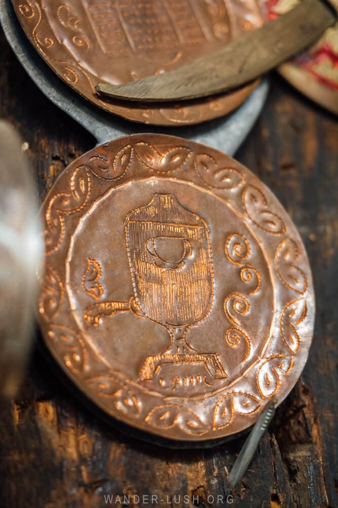 A small copper plate engraved with a samovar symbol.