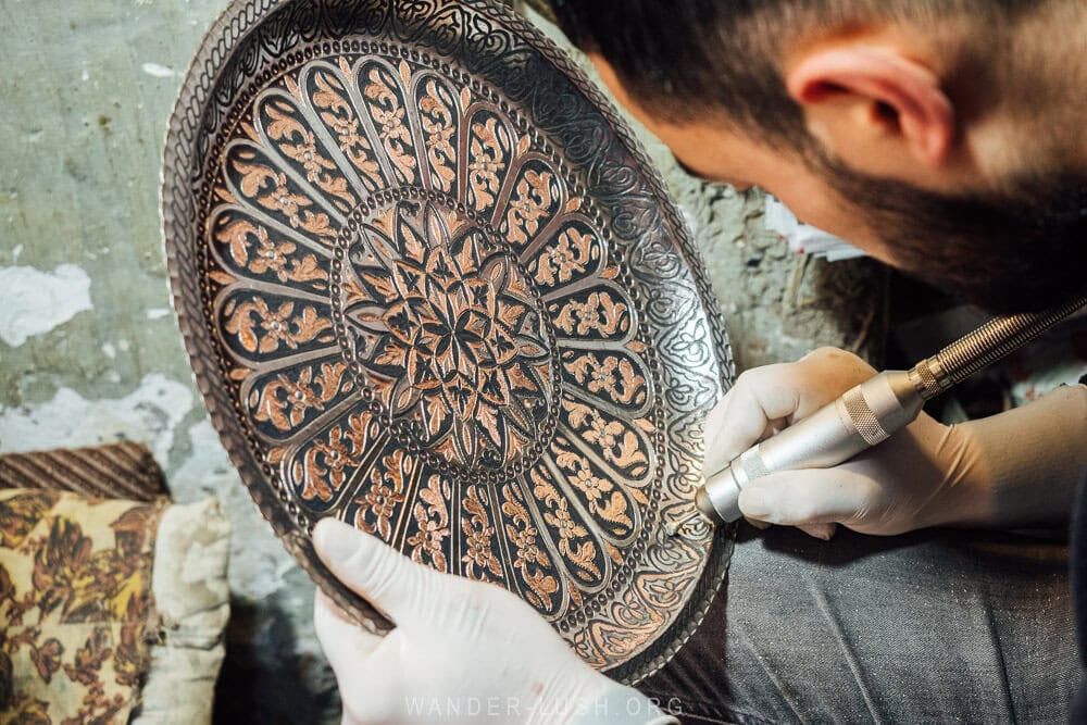 A man uses a modern tool to engrave a metal plate inside his workshop in Lahij in Azerbaijan.