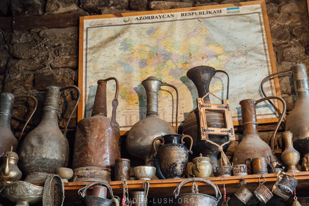 A collection of metal and bronze jugs and vessels sitting on a mantle inside an artisan workshop in Lahic Azerbaijan.