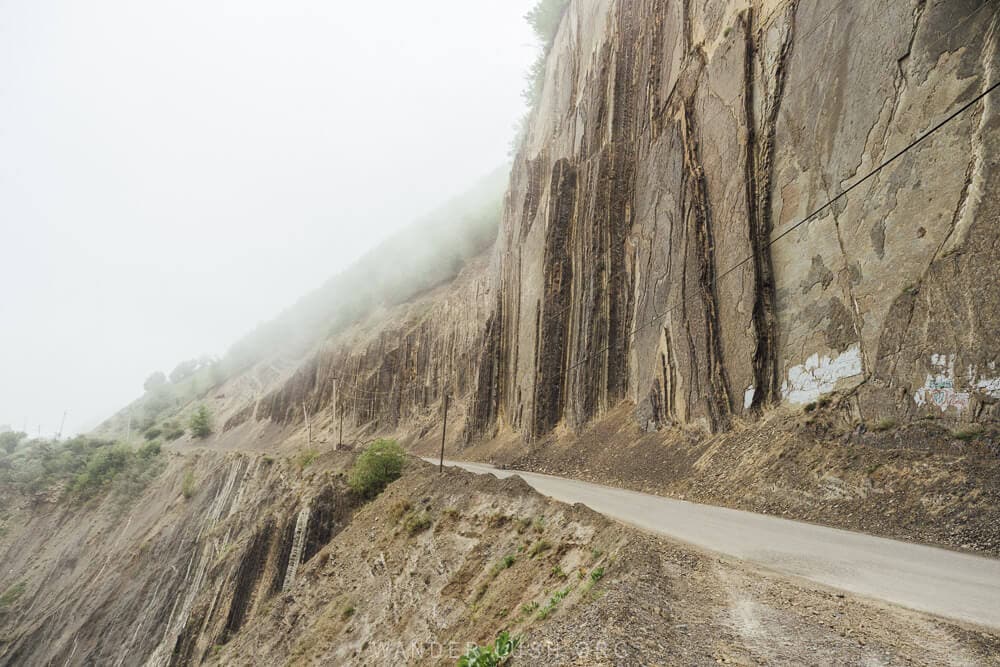 A narrow road cuts through steep mountain cliffs on the way to Lahic from Baku.