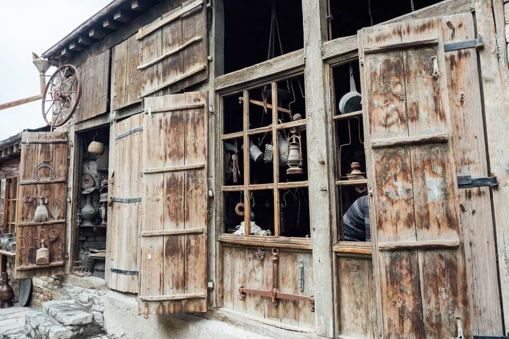 A row of copper workshops with wooden shutters and doors in Lahic.